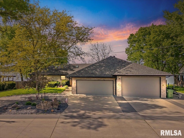 view of front facade featuring concrete driveway, a garage, a shingled roof, and brick siding