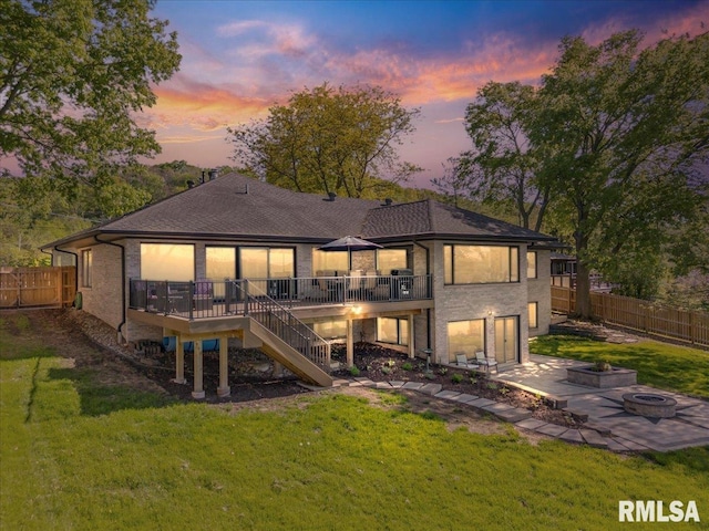back of property with an outdoor fire pit, a deck, stairs, a patio area, and a shingled roof