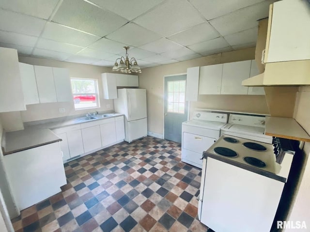 1202 17th Ave, Viola, IL 61486 - kitchen with white appliances, washer and clothes dryer, a drop ceiling, plenty of natural light, and a chandelier