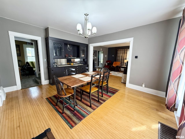 101 S Stewart St, Geneseo, IL 61254 - dining space featuring light wood-type flooring, a chandelier, and baseboards