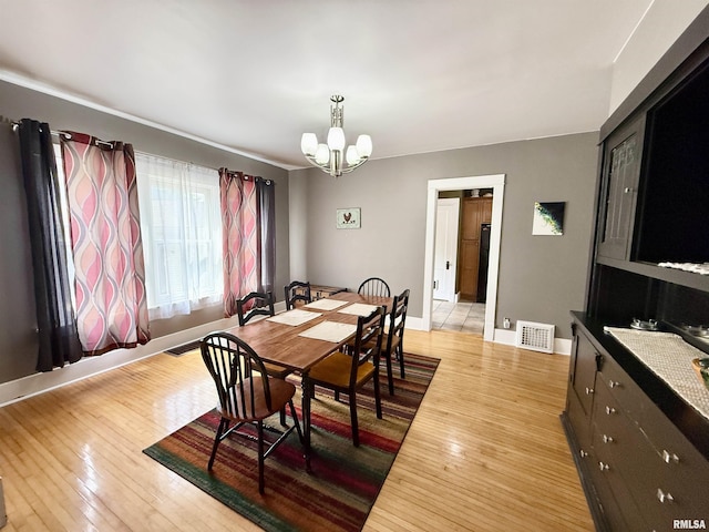 101 S Stewart St, Geneseo, IL 61254 - dining space featuring a chandelier, light wood-style flooring, and baseboards