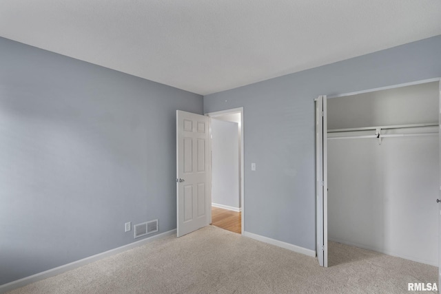 unfurnished bedroom with carpet floors, a closet, and baseboards
