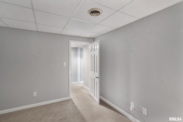 empty room with a drop ceiling, carpet floors, and baseboards