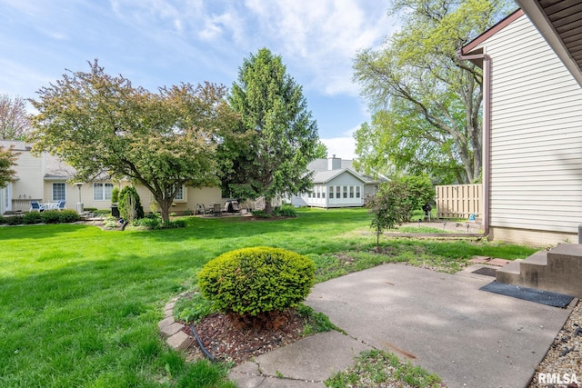 view of green lawn featuring a patio area
