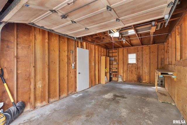 garage featuring a garage door opener and wood walls