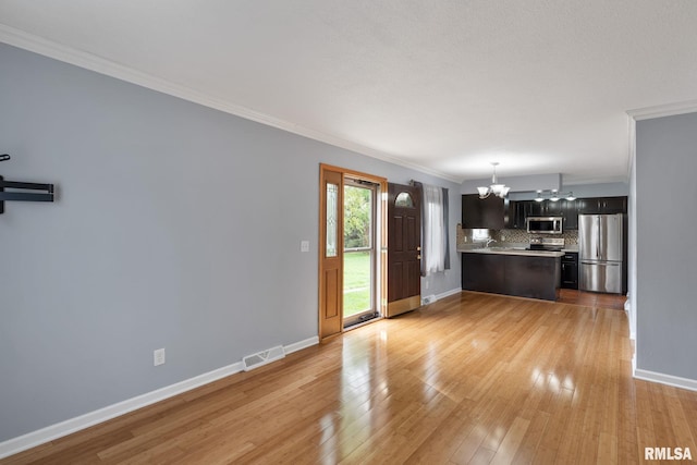 unfurnished living room with a chandelier, crown molding, baseboards, and light wood-style floors