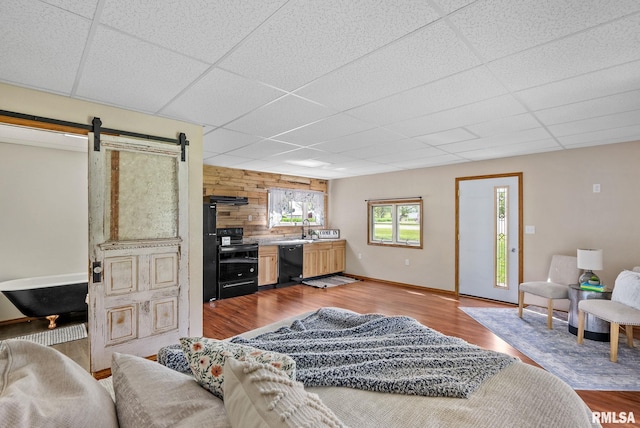 1709 Main St, Keithsburg, IL 61442 - living area featuring a paneled ceiling, a barn door, and wood finished floors