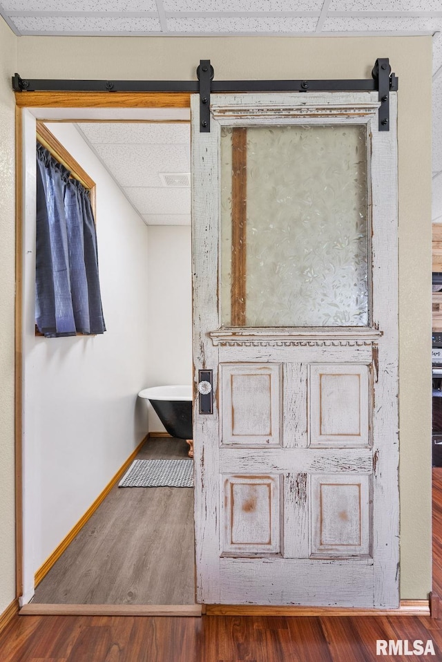 1709 Main St, Keithsburg, IL 61442 - detailed view of a drop ceiling, wood finished floors, baseboards, and a barn door