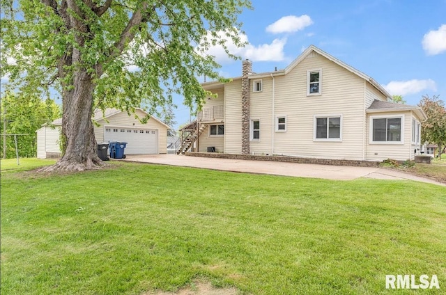 back of property with a lawn, a garage, an outdoor structure, and a chimney
