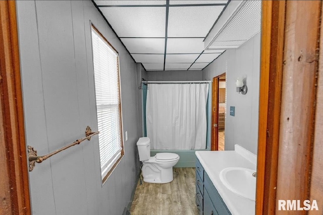 bathroom with wood finished floors, toilet, vanity, and shower / bathtub combination with curtain