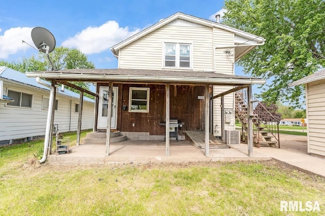 back of property with stairway, a patio area, and a yard