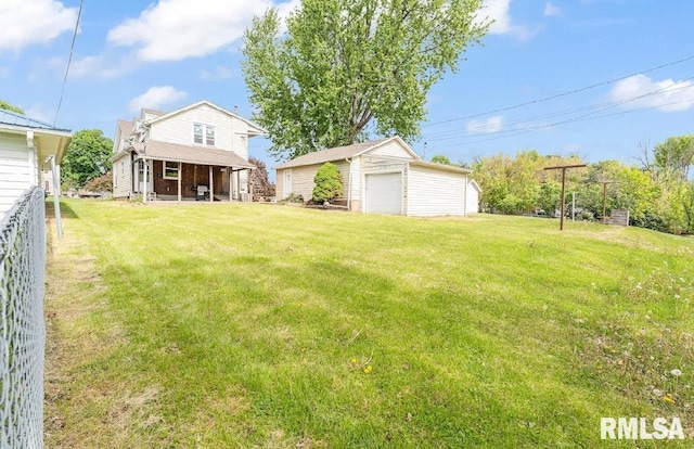 view of green lawn with a garage and an outbuilding