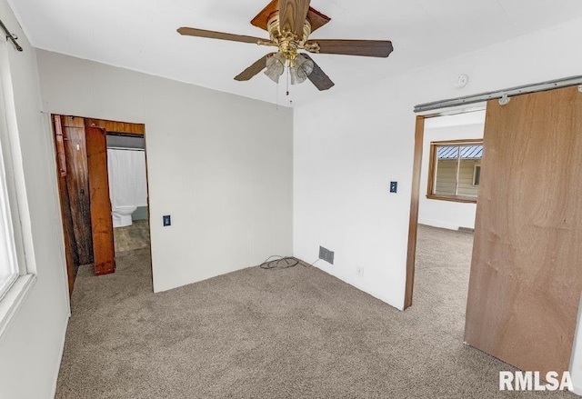 spare room with carpet and a ceiling fan