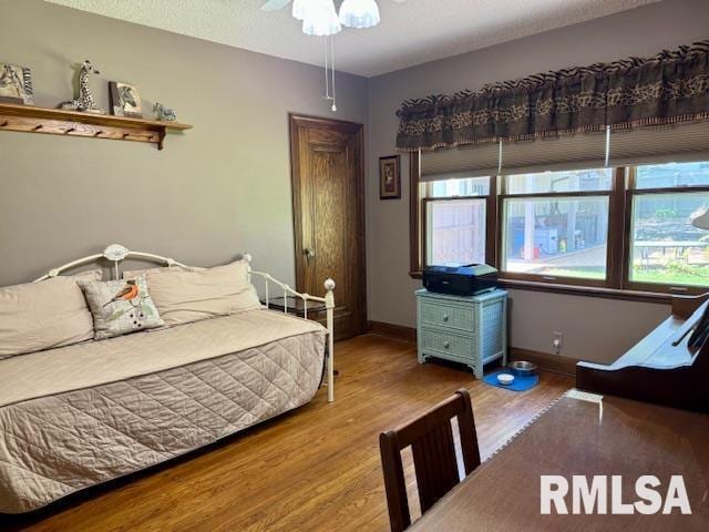 bedroom with wood finished floors and baseboards