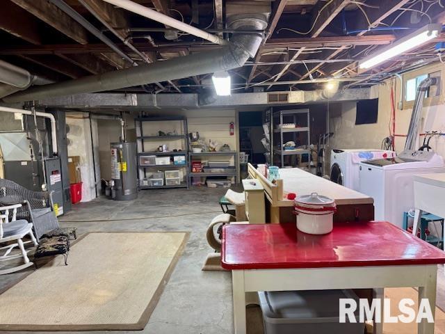 below grade area featuring water heater, washer and clothes dryer, and heating unit