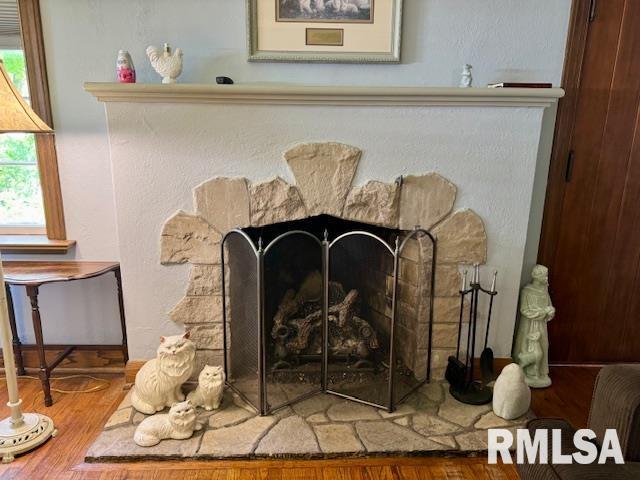 detailed view of a stone fireplace and wood finished floors