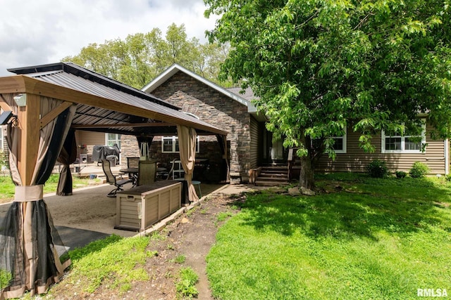 17503 N Woodlawn Ln, Woodlawn, IL 62898 - view of front facade featuring a gazebo, stone siding, a front yard, a patio, and metal roof