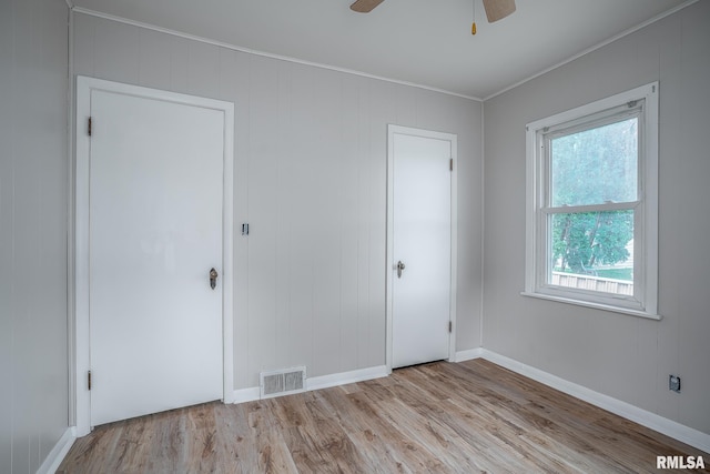 unfurnished bedroom featuring wood finished floors, baseboards, ornamental molding, and ceiling fan