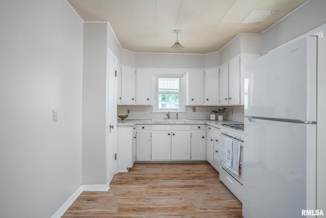 kitchen with white appliances, ornamental molding, white cabinetry, light wood finished floors, and a sink