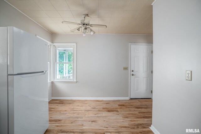 unfurnished room featuring a ceiling fan, baseboards, wood finished floors, and crown molding