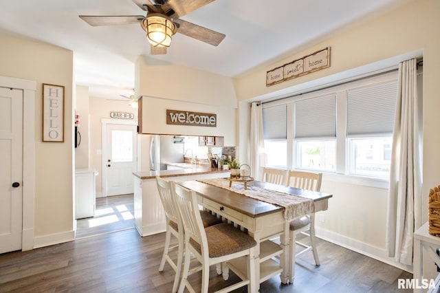 dining space featuring ceiling fan, dark wood-type flooring, and baseboards