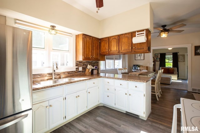 kitchen with freestanding refrigerator, a sink, a ceiling fan, stove, and dark wood-style floors
