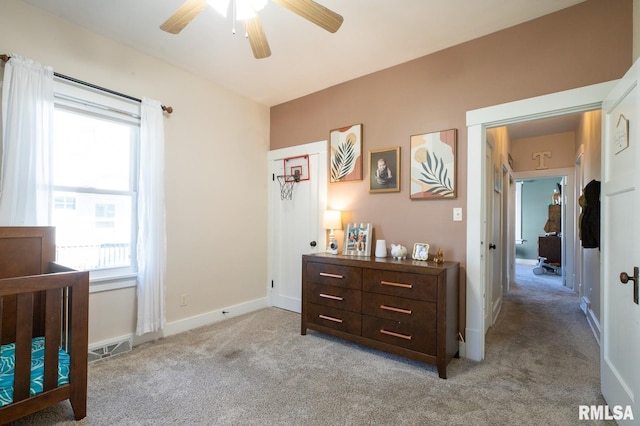 bedroom featuring light colored carpet, baseboards, and a ceiling fan