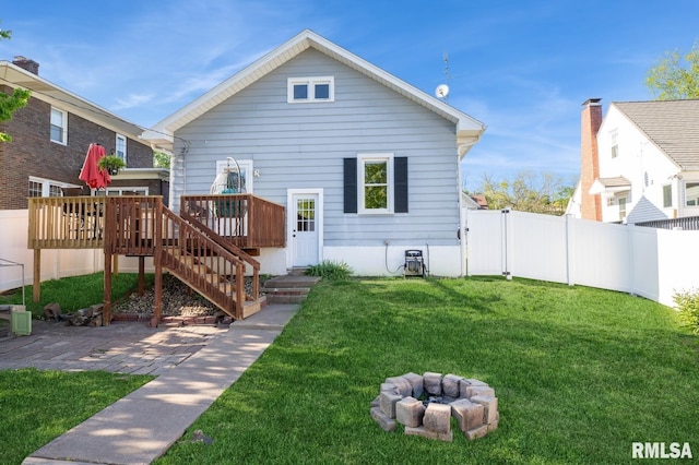 back of property featuring a deck, a fire pit, stairs, and a patio