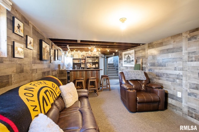 carpeted living room featuring a bar, wooden walls, and stairway