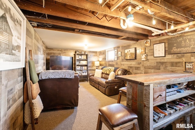 carpeted living area featuring wood walls