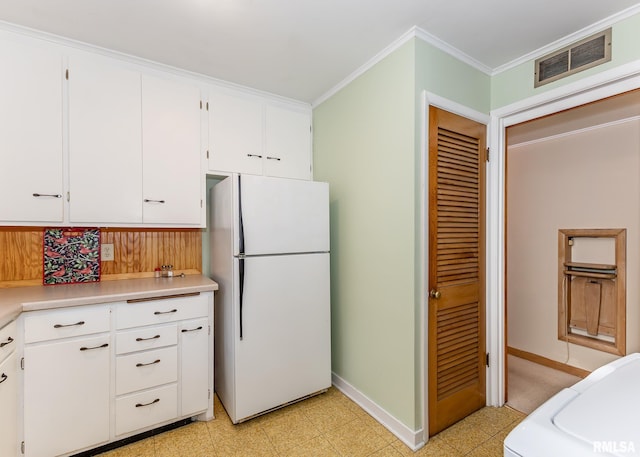 kitchen with freestanding refrigerator, crown molding, light countertops, baseboards, and white cabinetry