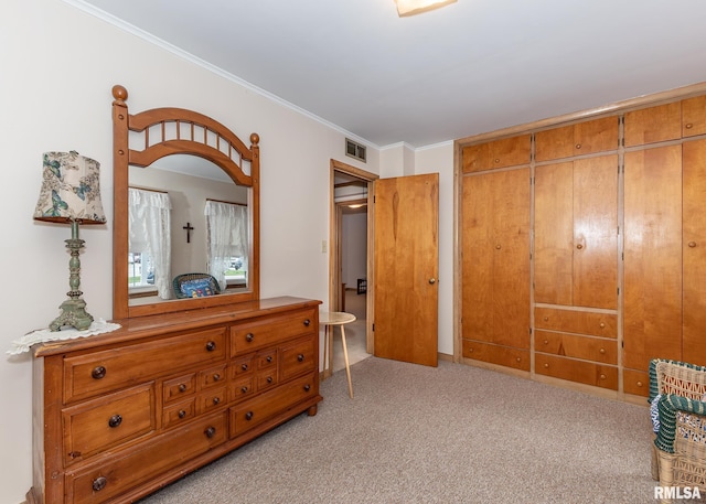bedroom with light carpet, crown molding, and a closet