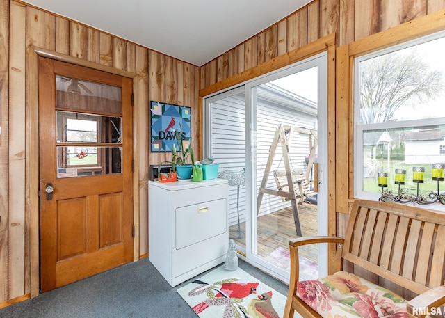 washroom with carpet flooring, washer / dryer, and wood walls
