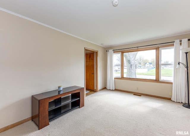spare room featuring baseboards, crown molding, light colored carpet, and a smoke detector