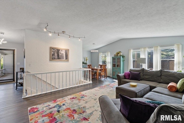 living room with wood finished floors, lofted ceiling, and a textured ceiling