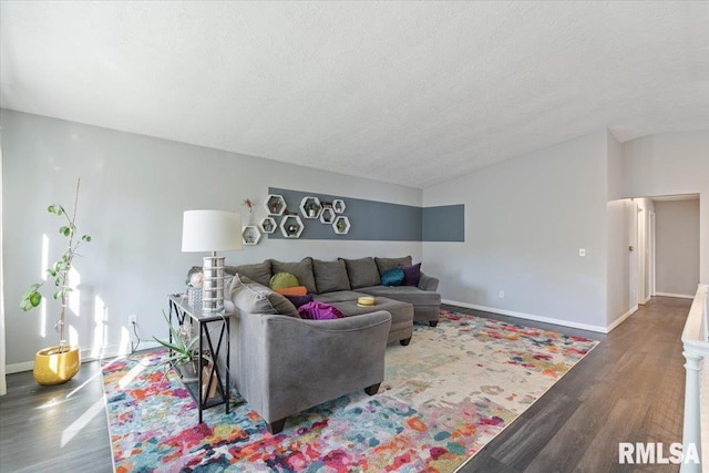 living room with wood finished floors, vaulted ceiling, a textured ceiling, and baseboards