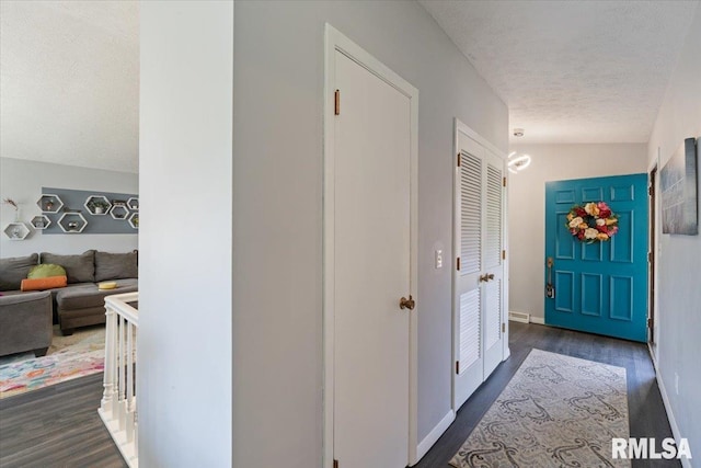 hall featuring dark wood finished floors and a textured ceiling
