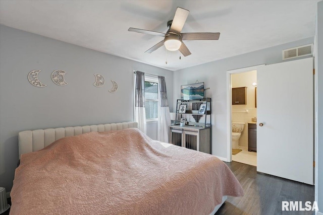 bedroom with dark wood-style floors, ensuite bath, radiator, and ceiling fan