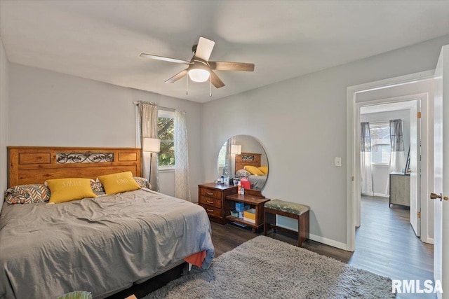 bedroom with multiple windows, dark wood-style floors, baseboards, and ceiling fan