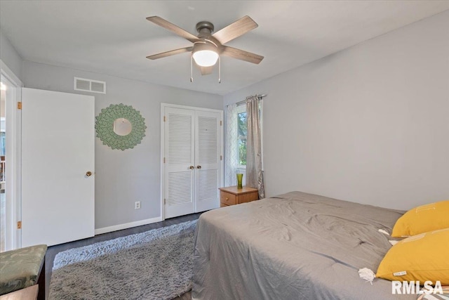 bedroom with wood finished floors, a closet, baseboards, and a ceiling fan