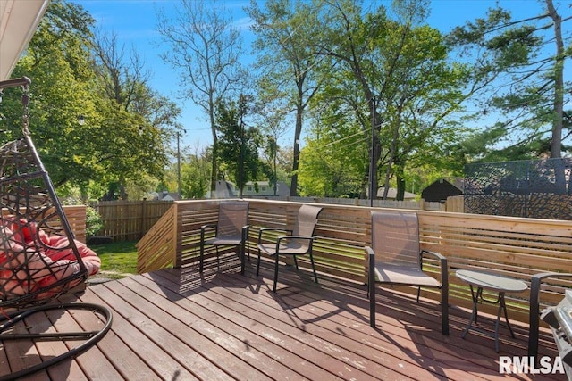 wooden deck with a fenced backyard and view of wooded area
