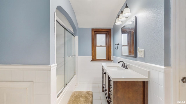 2117 Harrison St, Davenport, IA 52803 - full bathroom featuring wainscoting, vanity, combined bath / shower with glass door, tile patterned flooring, and lofted ceiling