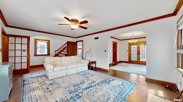 2117 Harrison St, Davenport, IA 52803 - living room featuring arched walkways, wood finished floors, baseboards, stairs, and a ceiling fan