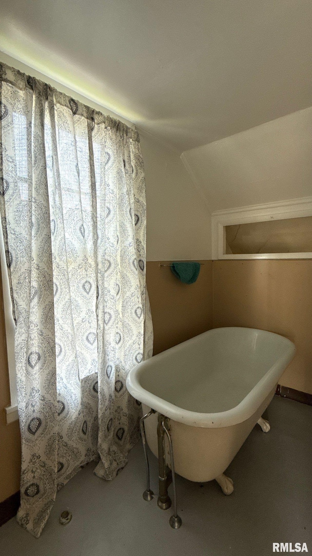 full bath featuring a freestanding tub and vaulted ceiling
