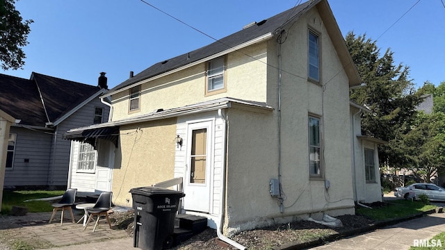 rear view of property featuring stucco siding and a patio