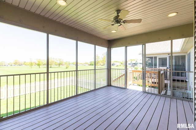 unfurnished sunroom with ceiling fan