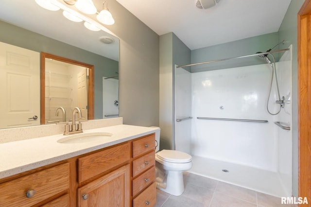 bathroom featuring vanity, tile patterned floors, a shower, and toilet
