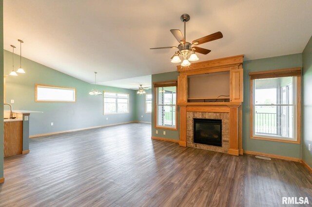 unfurnished living room with ceiling fan, dark wood-style floors, a glass covered fireplace, baseboards, and lofted ceiling