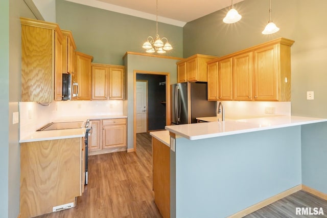 kitchen featuring light brown cabinets, a peninsula, high vaulted ceiling, and light wood finished floors
