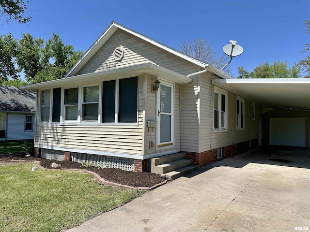 812 E Murray St, Macomb, IL 61455 - view of front of property featuring a carport, driveway, entry steps, crawl space, and a front lawn
